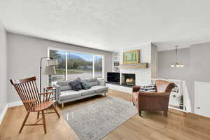 Living room with a wood burning brick fireplace and picture window.