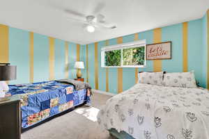 First Bedroom in the basement with a ceiling fan and carpet