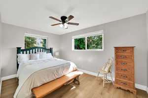 First Bedroom upstairs with light wood-style flooring, and ceiling fan