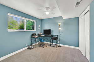 Second Bedroom in the basement used as office space featuring carpet floors and ceiling fan
