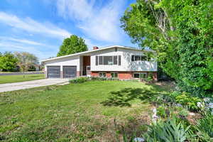 Bi-level home with an attached garage and a creek that runs along the North side