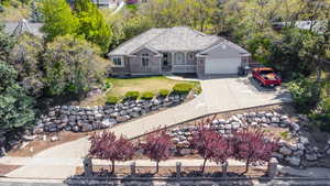 View of front of home featuring a fenced front yard, an attached garage, driveway, and a front lawn