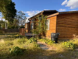 View of side of home with a wooden deck and fence