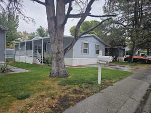 View of front of property with a sunroom and a front lawn
