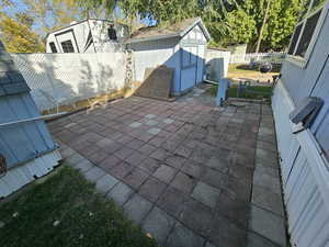 View of patio / terrace featuring a storage shed, an outbuilding, and a fenced backyard