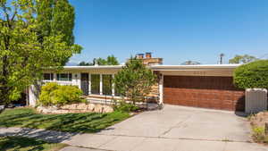 Ranch-style home featuring an attached garage and concrete driveway