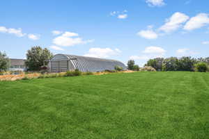 View of yard featuring an outdoor structure and a pole building