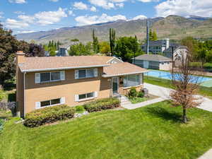 View of front of property with fence, a mountain view, a chimney, and a front yard