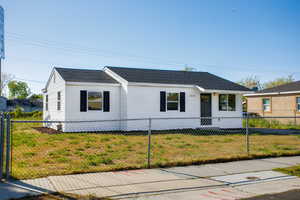 Single story home with a fenced front yard, roof with shingles, and a front yard