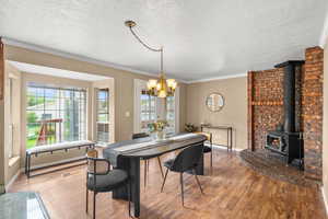 Dining space with plenty of natural light, laminate  wood floors and wood burning stove.