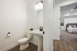 Bathroom with baseboards, toilet, and wood finished floors