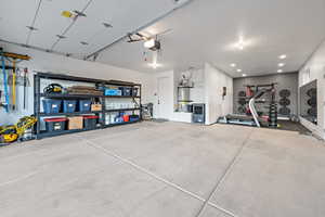Garage featuring recessed lighting, water heater, and a garage door opener