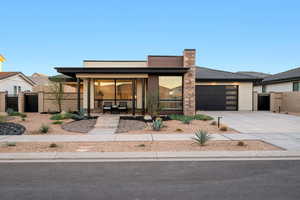 View of front of home featuring a garage, fence, a gate, concrete driveway, and a porch