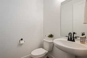 Bathroom with baseboards, a sink, and toilet