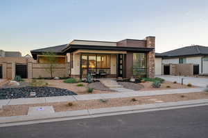 Prairie-style home with a porch, an attached garage, fence, and a gate
