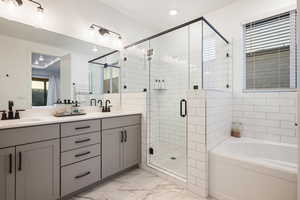 Full bathroom featuring a sink, double vanity, marble finish floor, a bath, and a stall shower