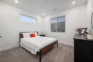 Carpeted bedroom featuring visible vents, recessed lighting, and baseboards