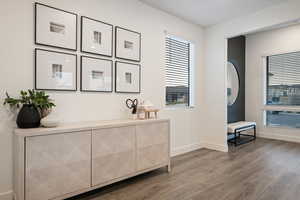 Interior space featuring baseboards, plenty of natural light, and wood finished floors