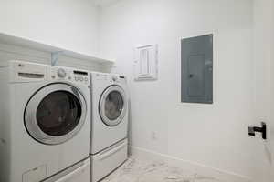 Washroom with laundry area, separate washer and dryer, marble finish floor, baseboards, and electric panel