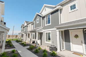 View of front of home with board and batten siding, a residential view, and central AC unit