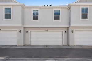 Exterior space featuring a garage, board and batten siding, and stucco siding