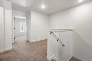 Upstairs landing bonus area featuring baseboards, light carpet, recessed lighting