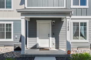 Entrance to property with central AC unit and board and batten siding