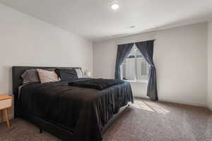 Primary bedroom featuring baseboards and carpet