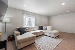 Living room with recessed lighting, baseboards, and light wood finished floors