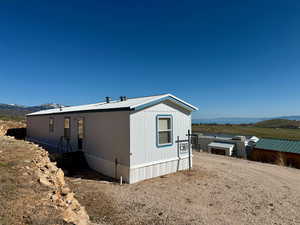 View of side of property featuring a mountain view and metal roof