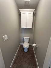 Bathroom featuring visible vents, baseboards, tile patterned floors, and toilet