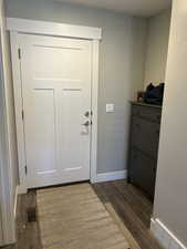 Doorway to garage featuring baseboards, dark wood-type flooring, and visible vents
