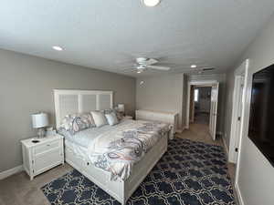 Bedroom featuring recessed lighting, a textured ceiling, baseboards, and carpet