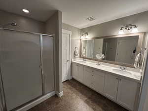 Full bath featuring visible vents, a sink, double vanity, and a shower stall