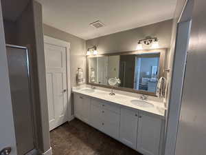Ensuite bathroom featuring double vanity, a stall shower and sink.