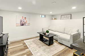 Living area featuring light wood-type flooring, recessed lighting, and baseboards