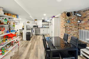 Dining space featuring light wood-style floors and visible vents