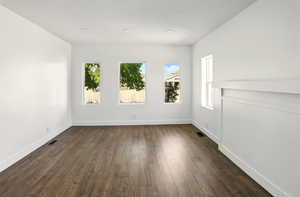 Empty room featuring baseboards, recessed lighting, dark wood-style floors, and visible vents
