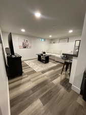 Living room featuring dark wood-style flooring, baseboards, and recessed lighting