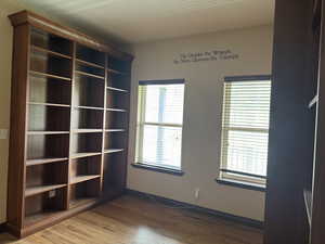 Unfurnished room featuring wood finished floors and baseboards
