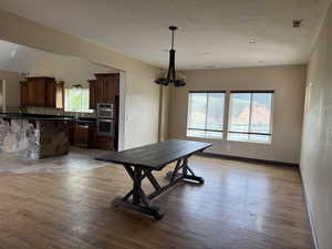 Dining room featuring a chandelier, light wood-type flooring, and baseboards
