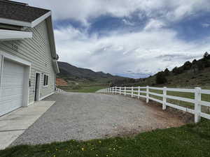 View of yard with fence, a garage, and a mountain view