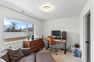 Carpeted home office featuring visible vents