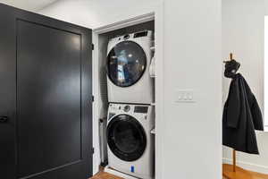 Clothes washing area featuring laundry area and stacked washer / dryer