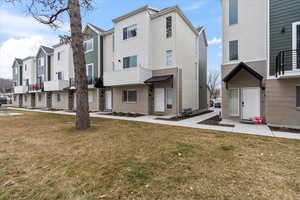 Multi unit property featuring a front lawn and a residential view