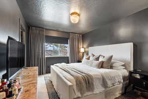 Carpeted bedroom featuring a textured ceiling