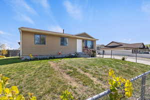 View of front of property with fence and a front yard
