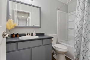 Full bath with vanity, shower / bath combo, and toilet
