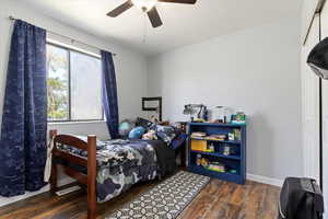 Bedroom featuring baseboards, a ceiling fan, and wood finished floors