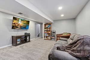Living room featuring stairway, baseboards, and carpet flooring